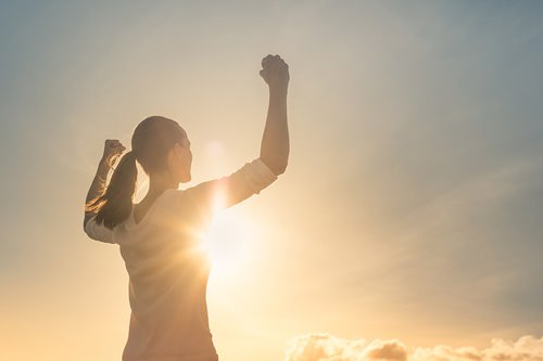 Women standing strong showing her muscles. 