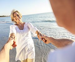 Woman holding man at beach